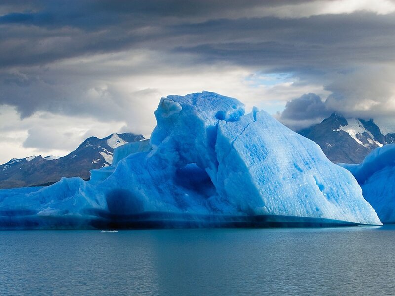 Blue Iceberg in Water — Dramatic, Photograph, Mountains, Clouds, Gray