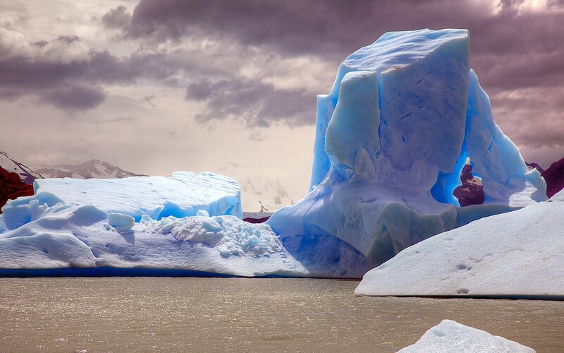 Blue Iceberg in Water — Dramatic, Photograph, Mountains, Clouds