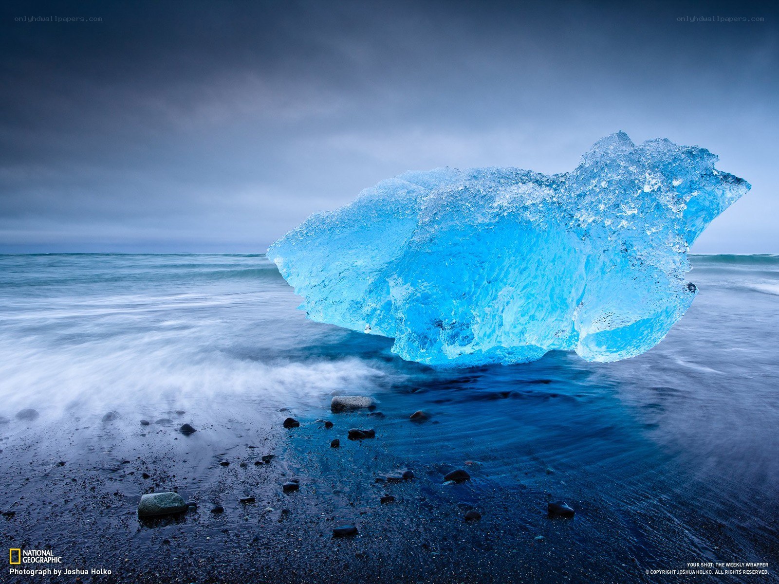 Blue icebergs on black sand beach