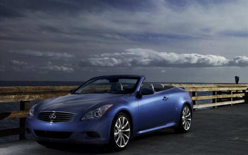 Blue Infiniti convertible by the sea