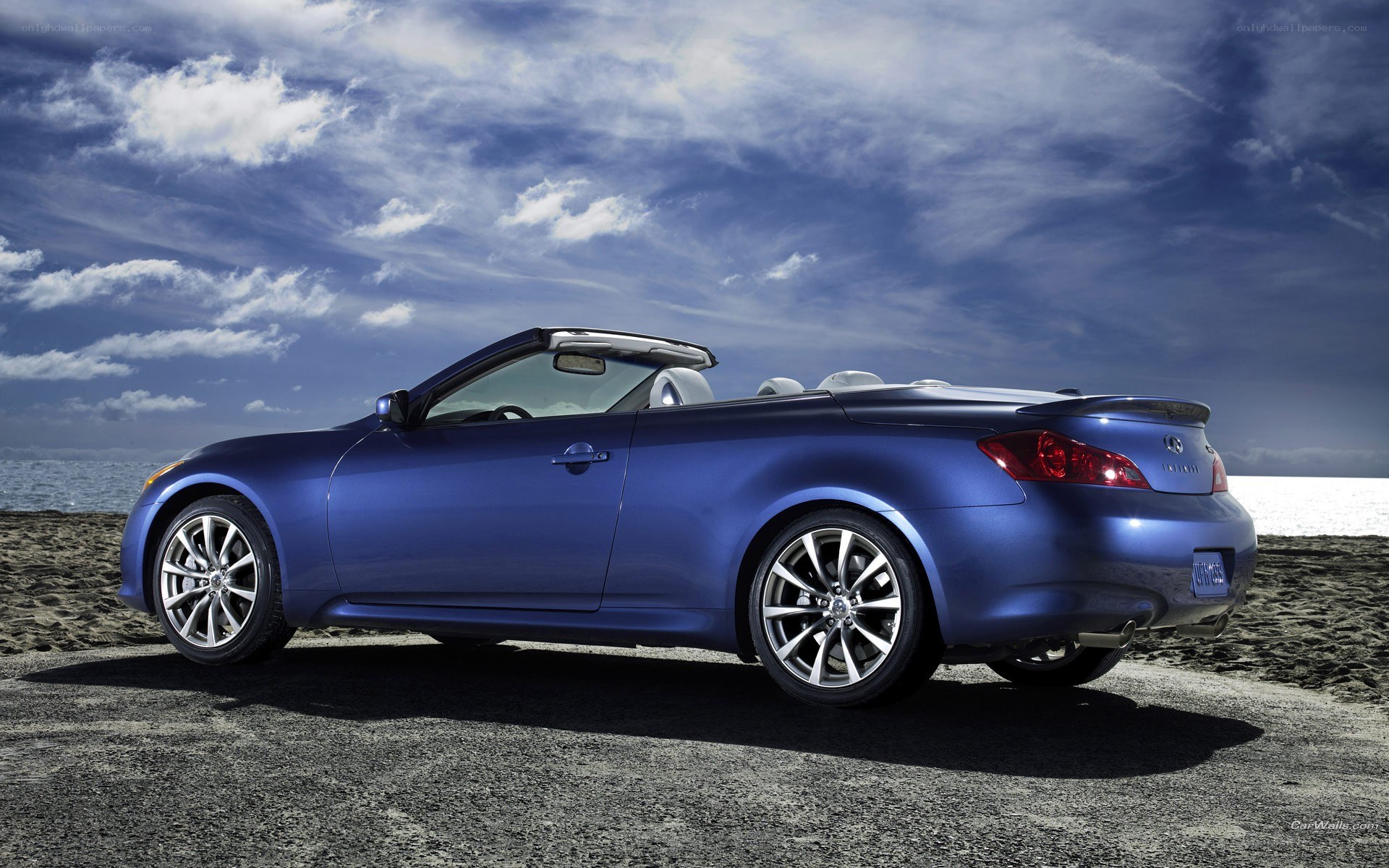 blue infiniti convertible on beach