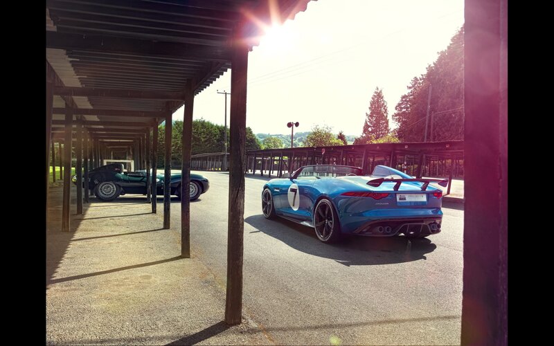 Blue Jaguar and classic car in garage