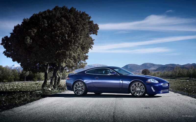 Blue Jaguar car on a country road