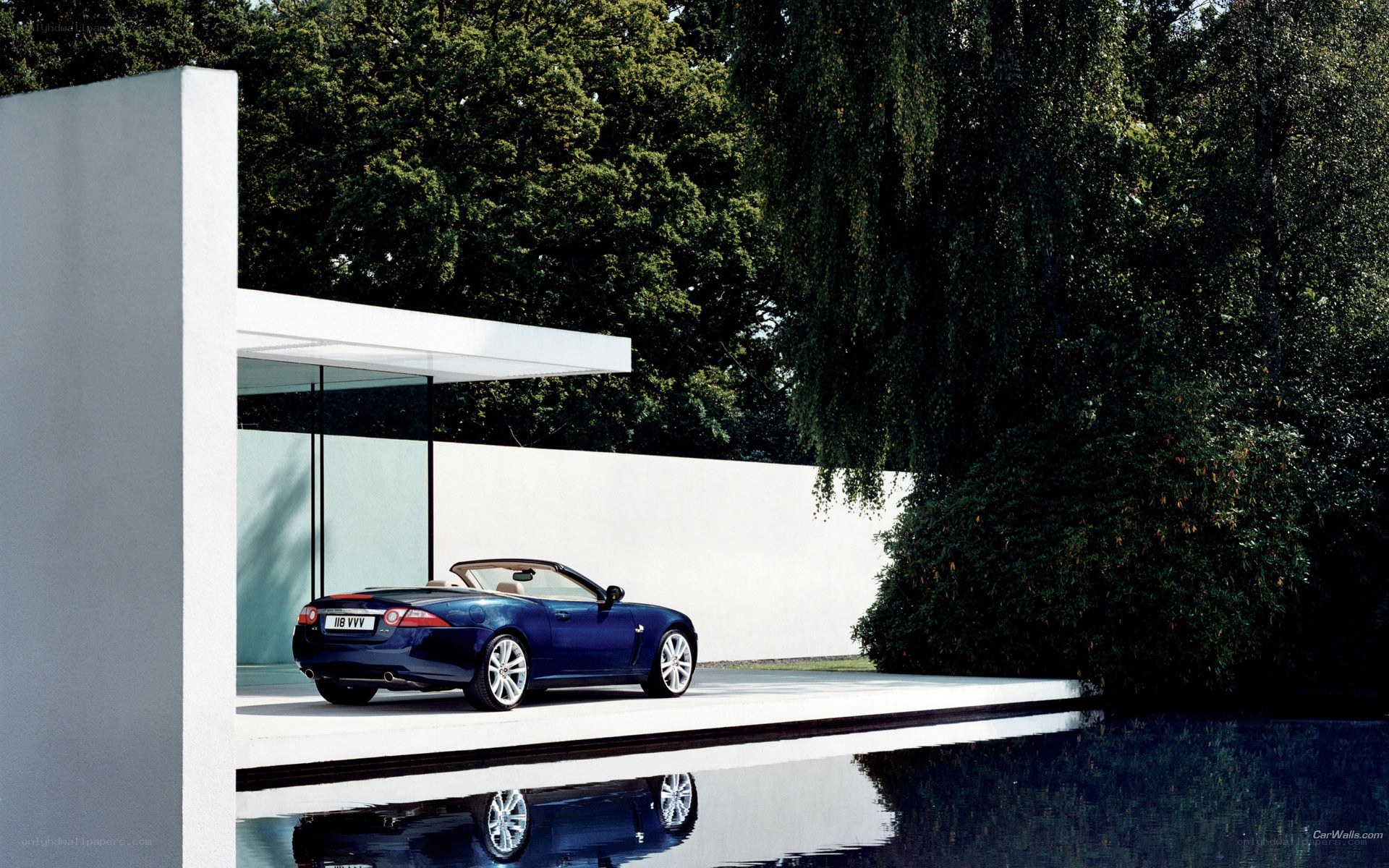 Blue Jaguar convertible by pool