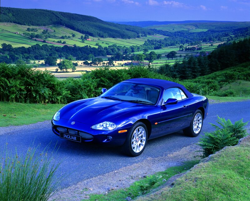 Blue Jaguar convertible on a country road
