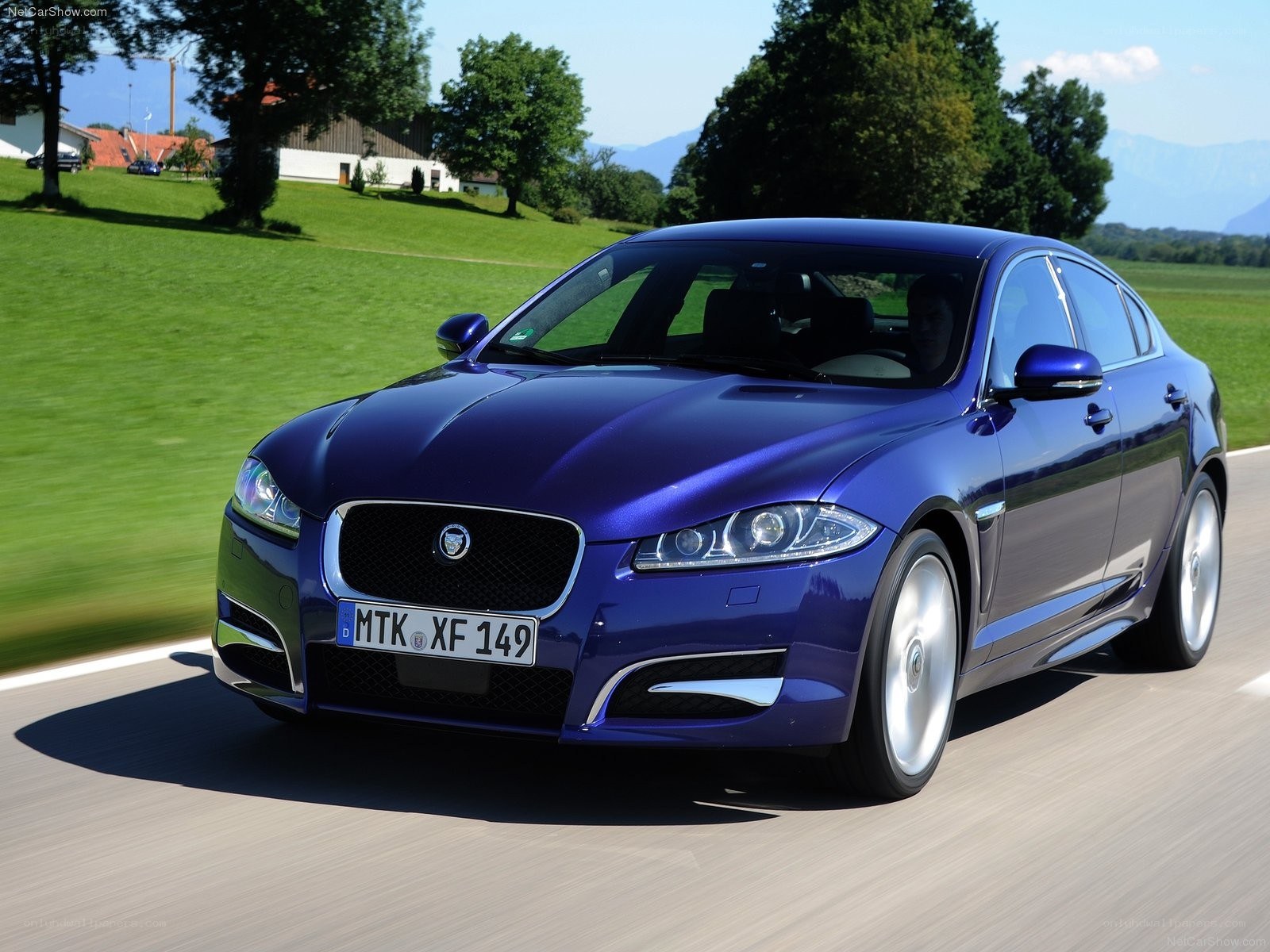 blue jaguar driving on road