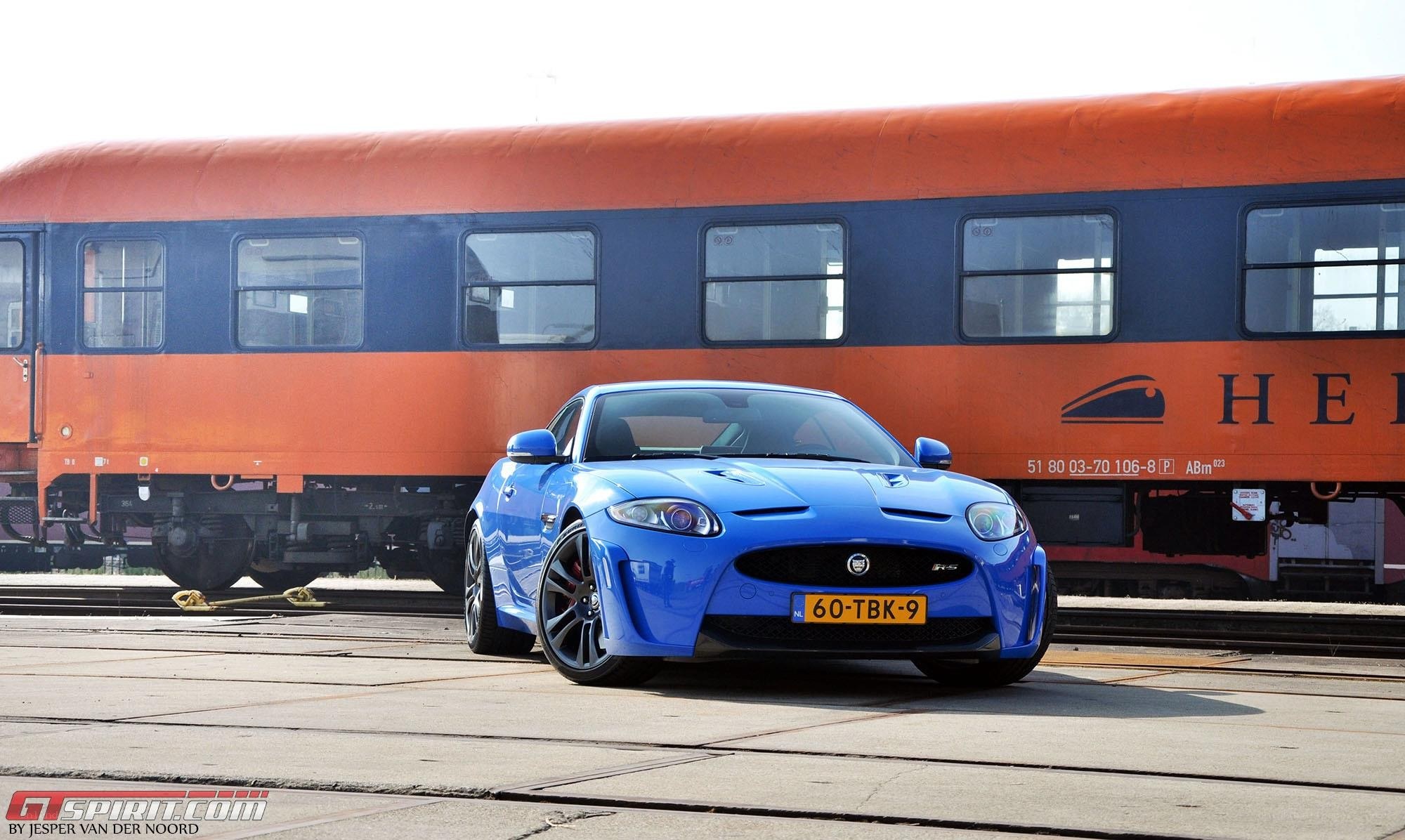 Blue Jaguar F-Type on train tracks
