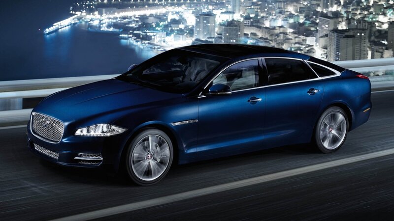 Blue Jaguar luxury sedan at night