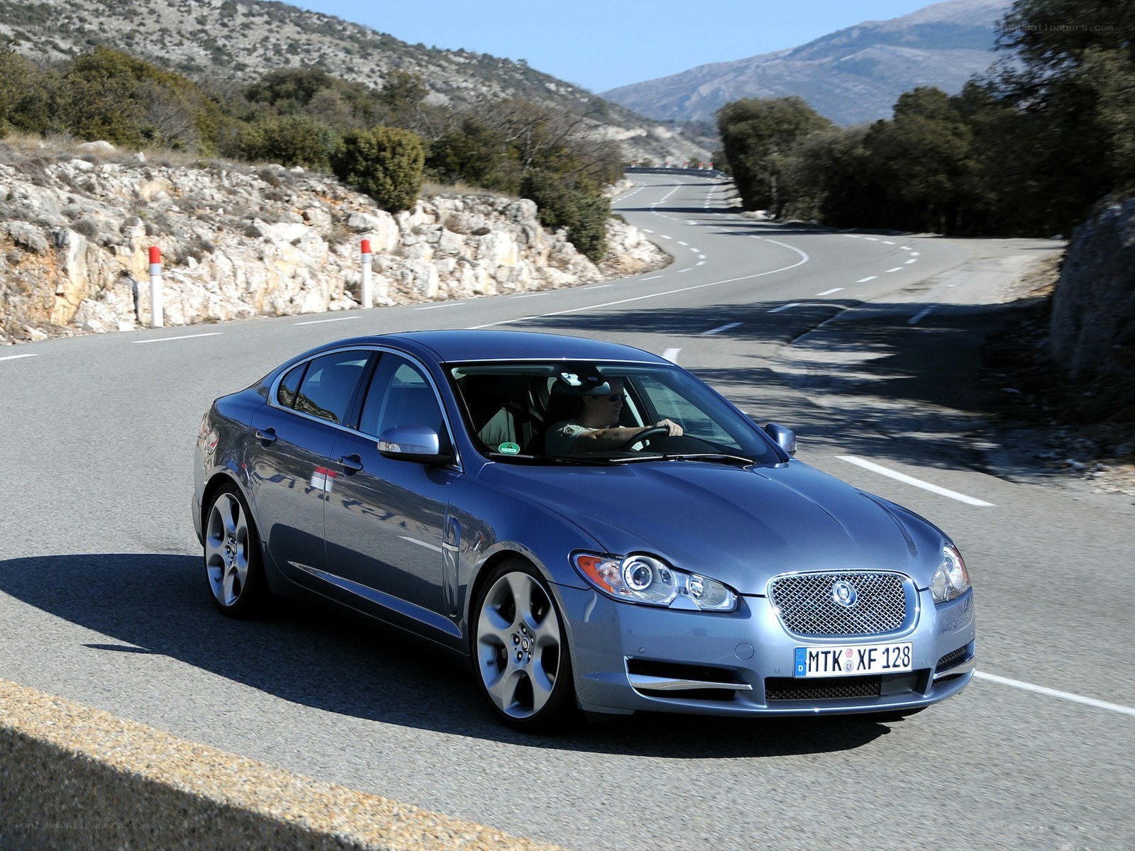blue jaguar on winding road