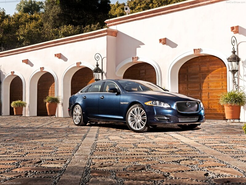 Blue Jaguar XJ parked in courtyard