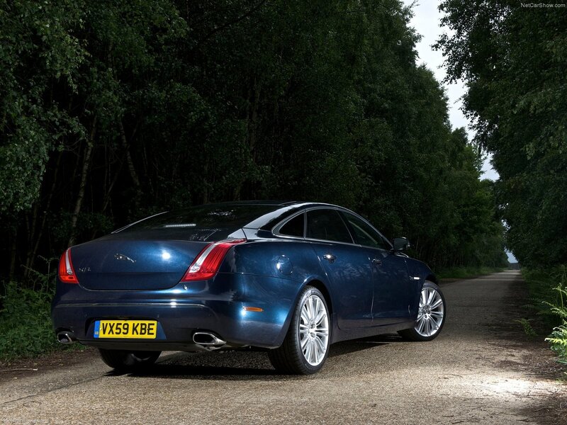 Blue Jaguar XJ parked on a forest road