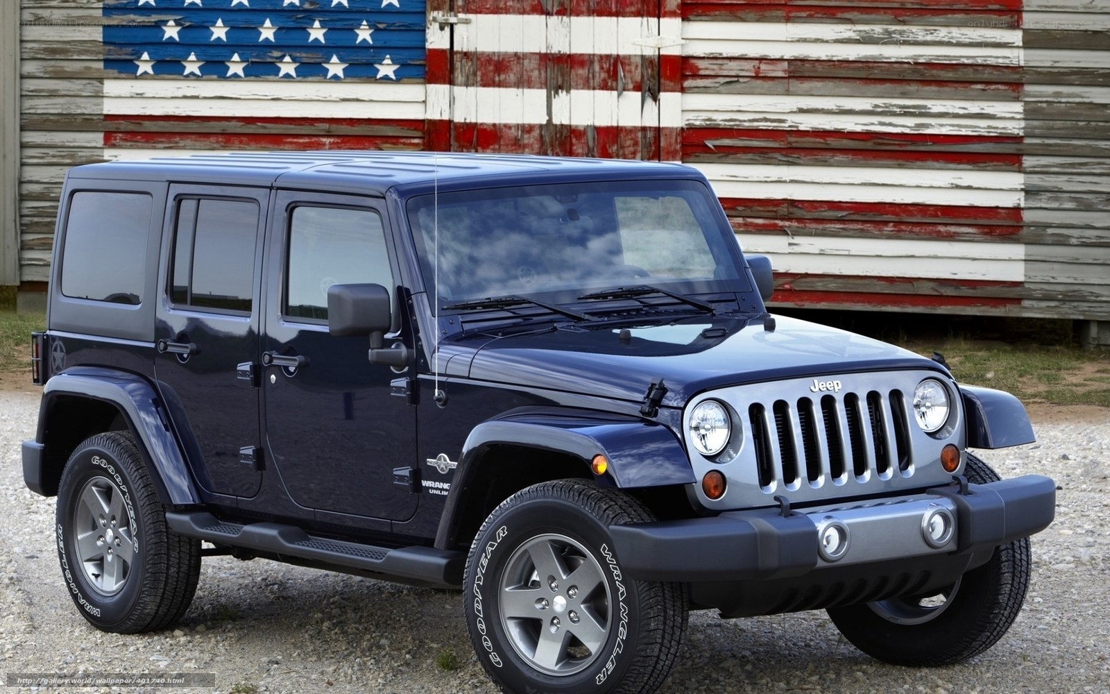 Blue Jeep Wrangler in front of American flag