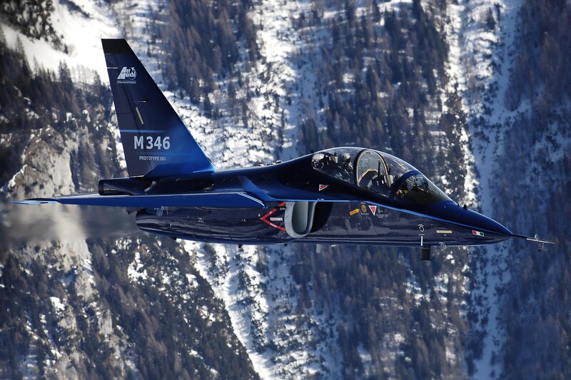 Blue jet flying over snowy mountains
