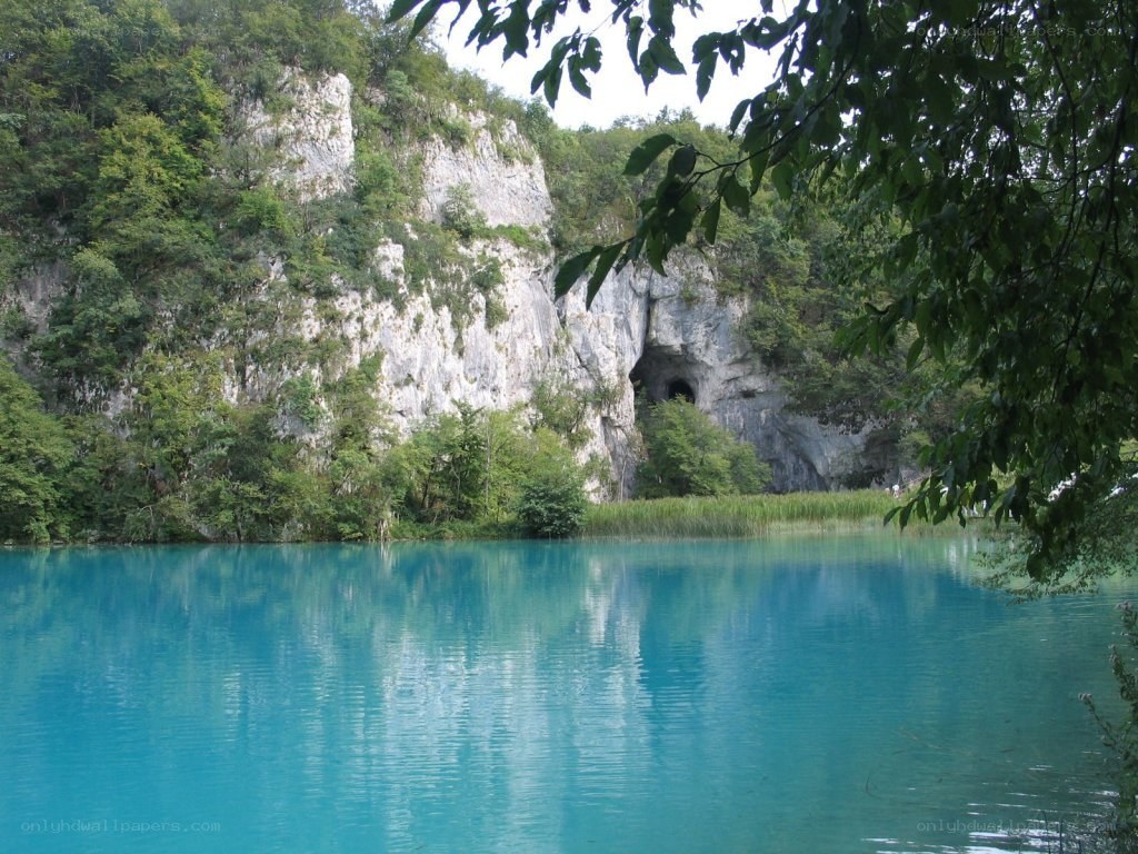 Blue lake with cave entrance