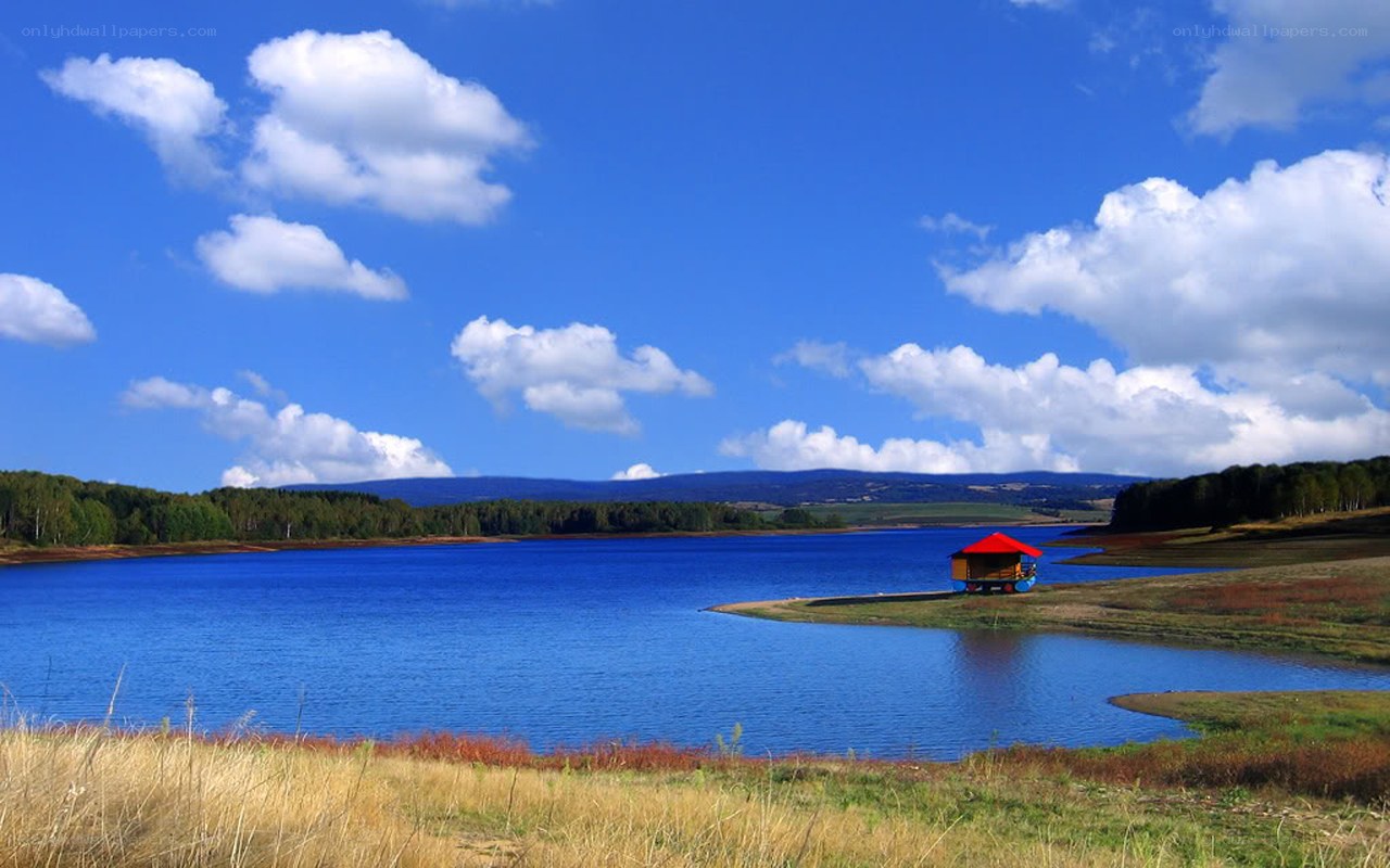 Blue lake with red-roofed hut
