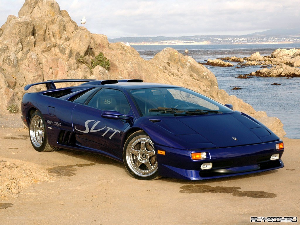 blue lamborghini on rocky shore
