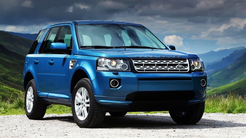 Blue Land Rover in mountain landscape