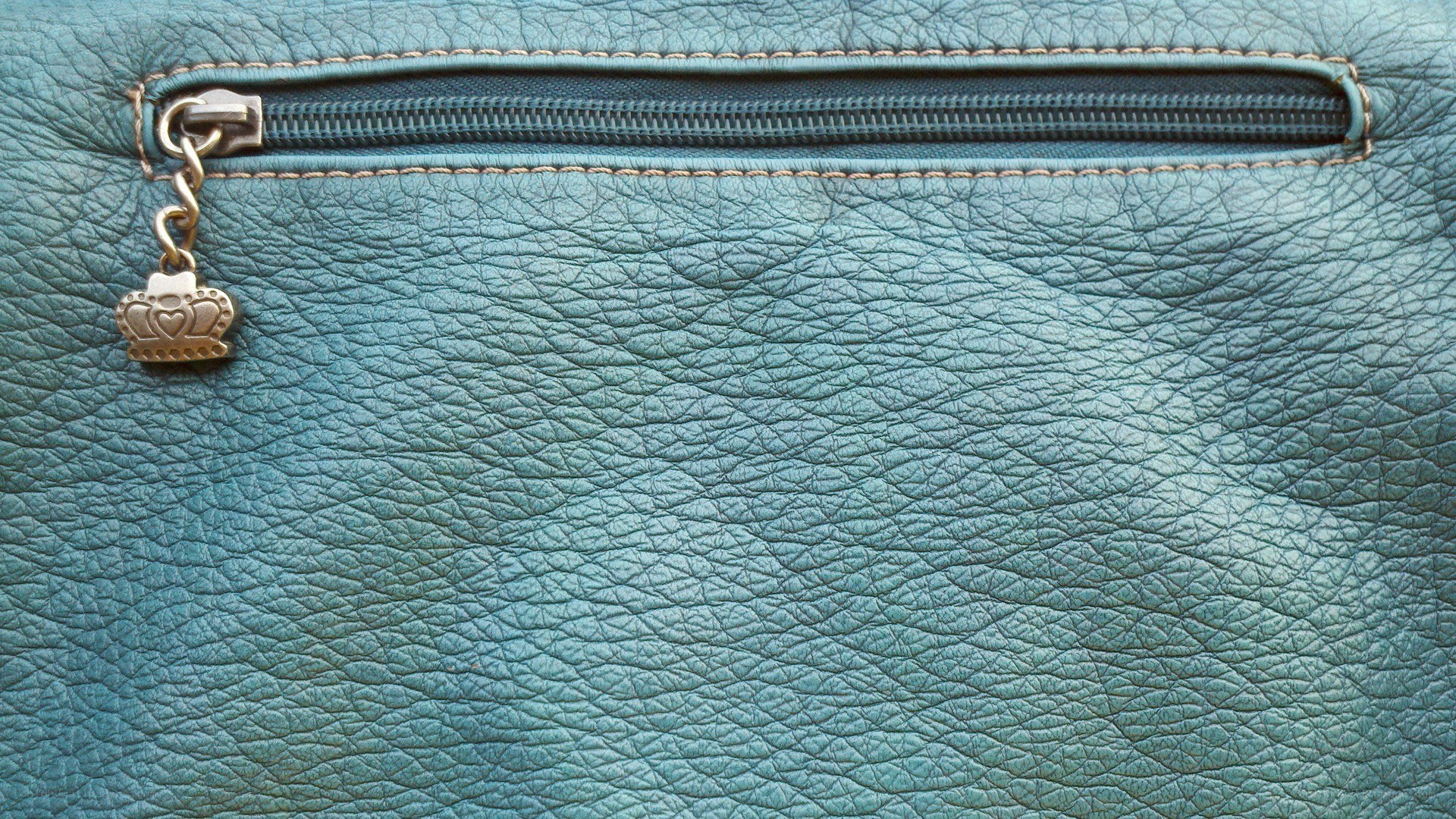 blue leather purse with crown zipper pull