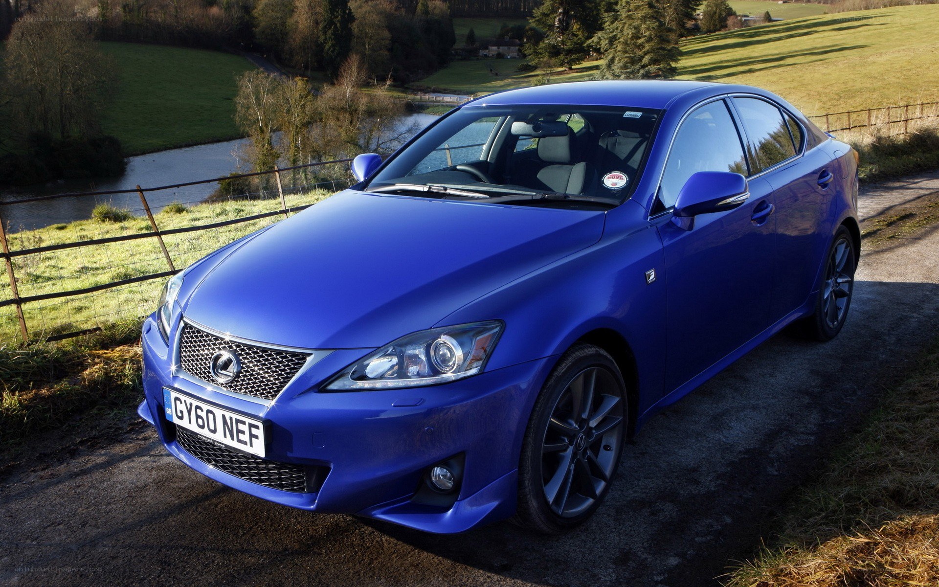Blue Lexus IS250 parked by river