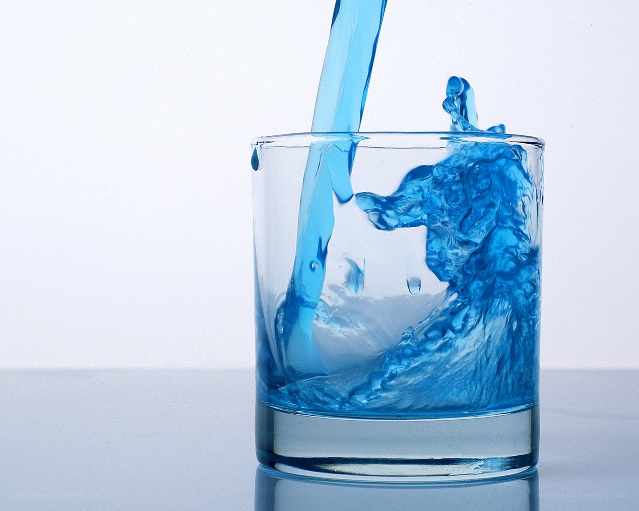 blue liquid pouring into glass