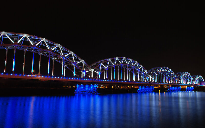 Blue-lit arched bridge at night