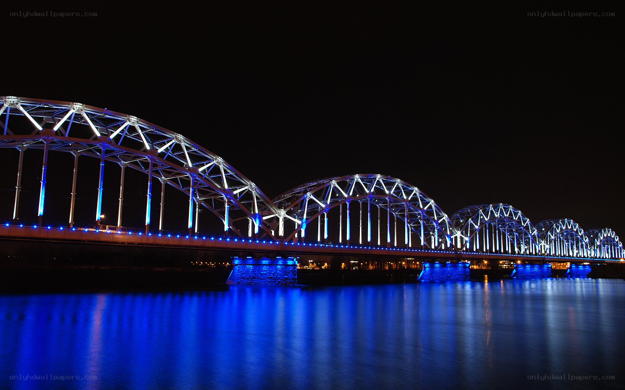 Blue-lit arched bridge at night