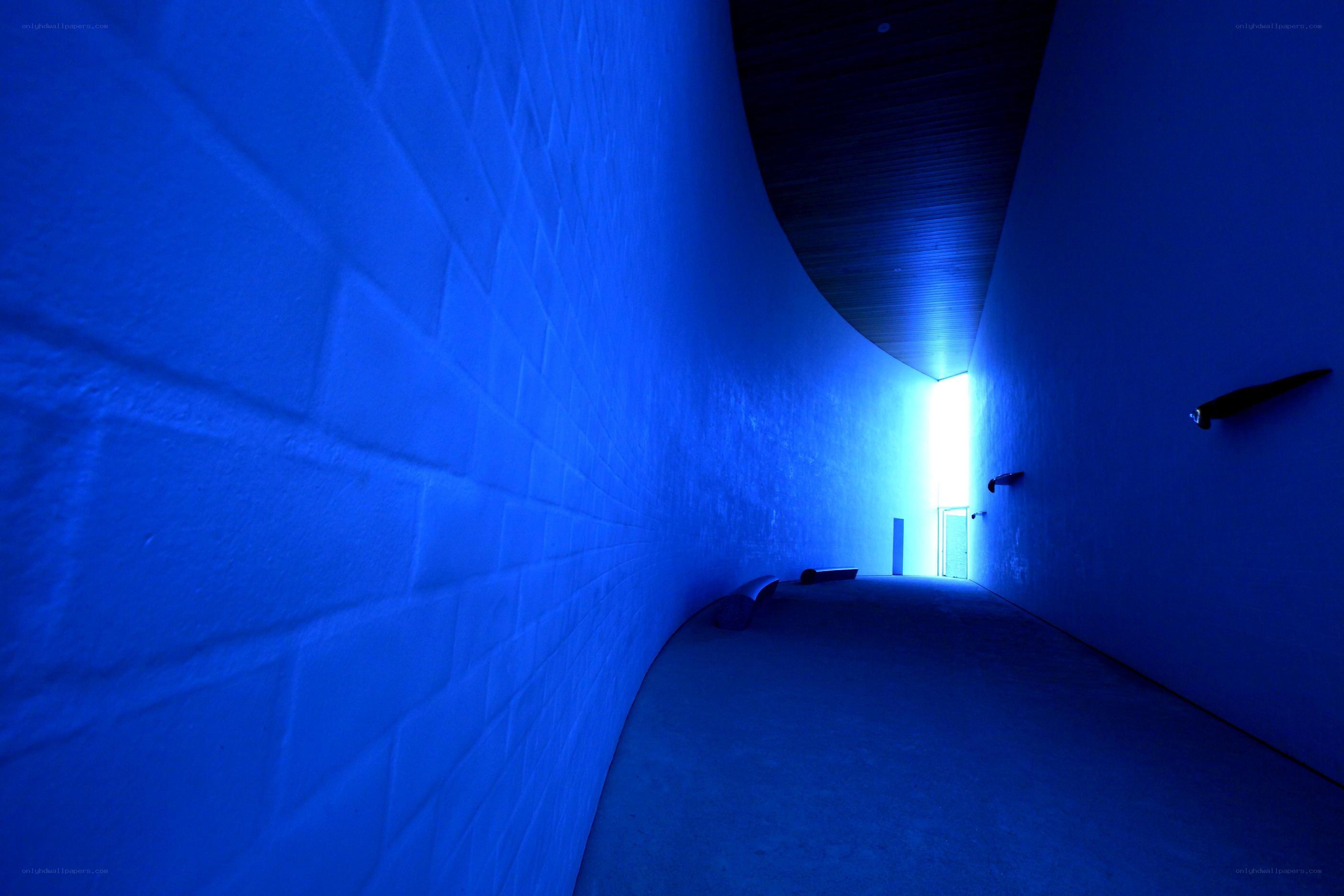 blue-lit curved corridor