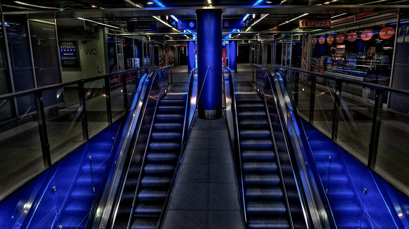 Blue-lit escalators in a subway