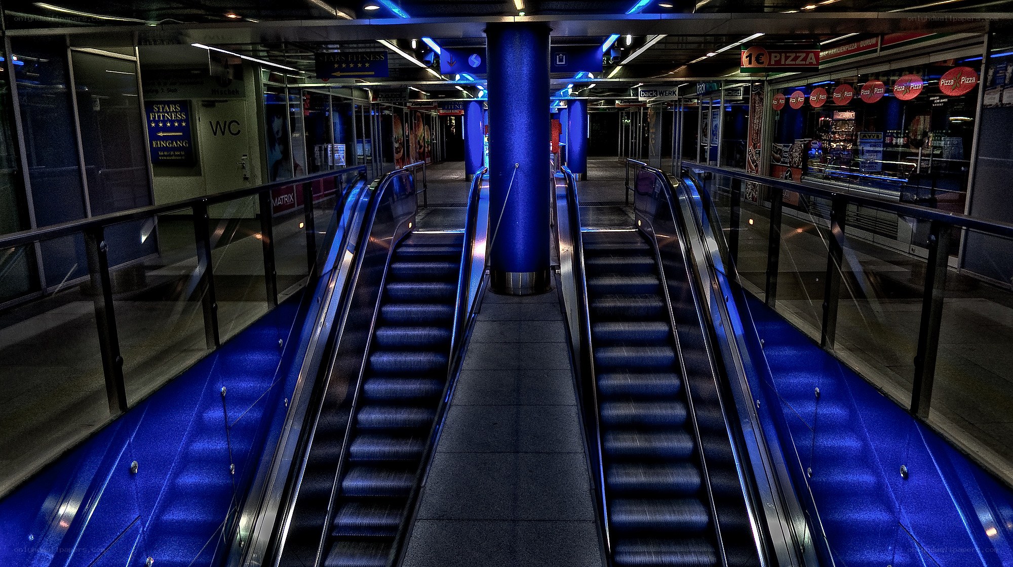 Blue-lit escalators in a subway