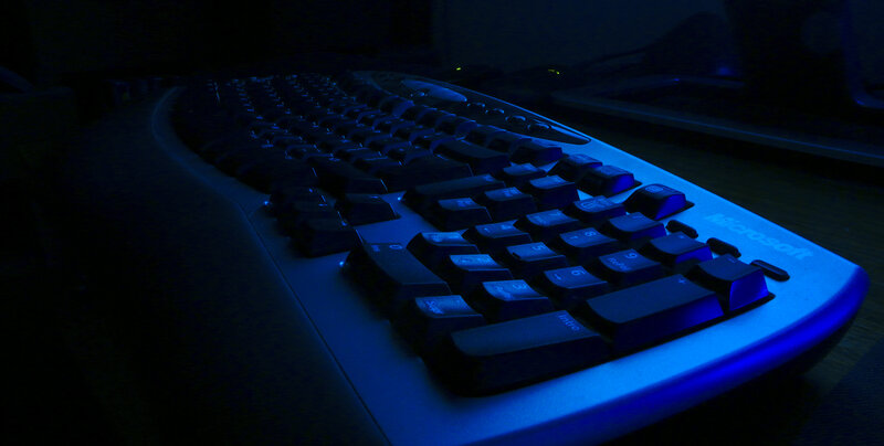blue-lit keyboard in dark room