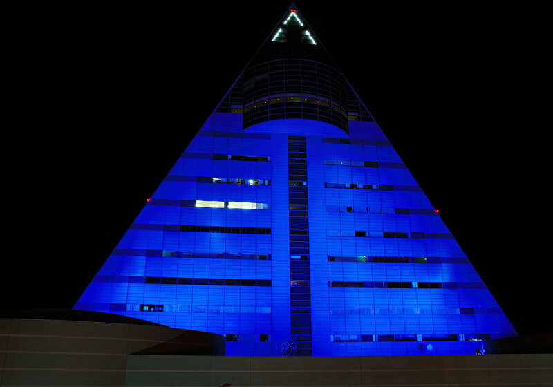 blue-lit pyramid building at night
