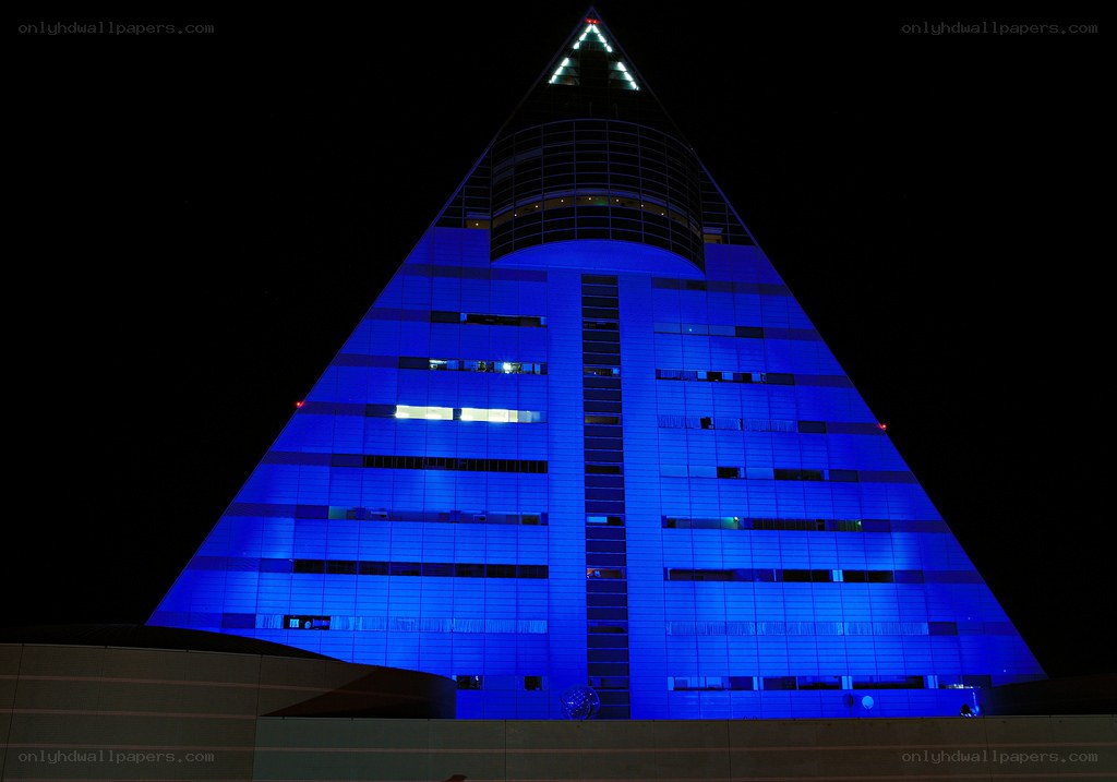 blue-lit pyramid building at night