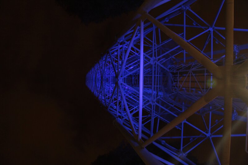 blue-lit tower structure at night