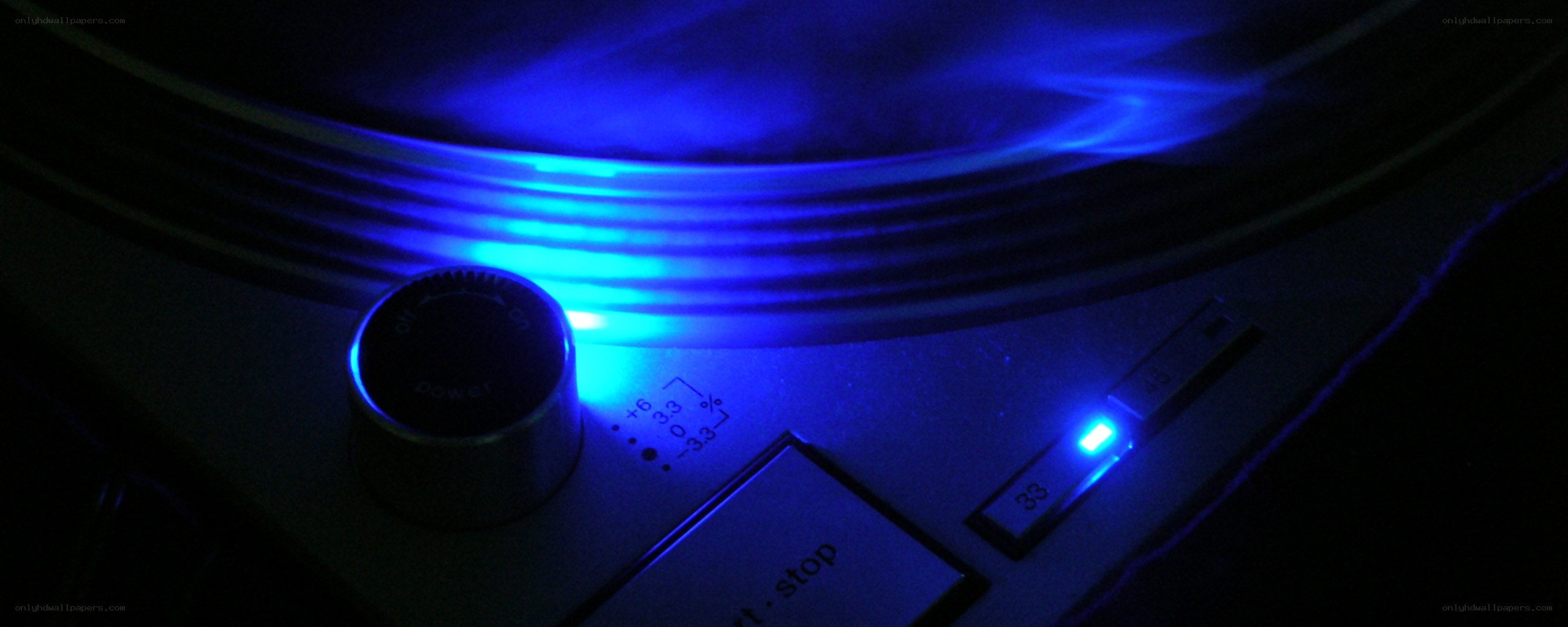 blue-lit turntable in dark room
