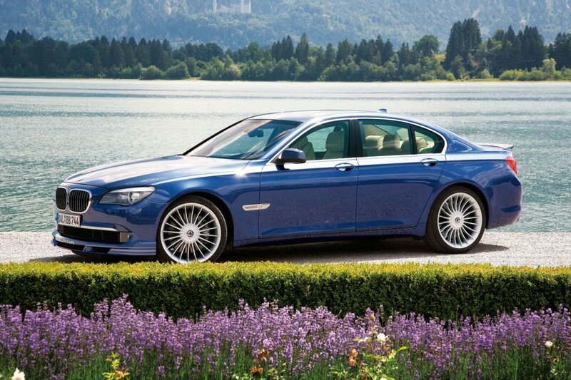 Blue luxury sedan by a lake
