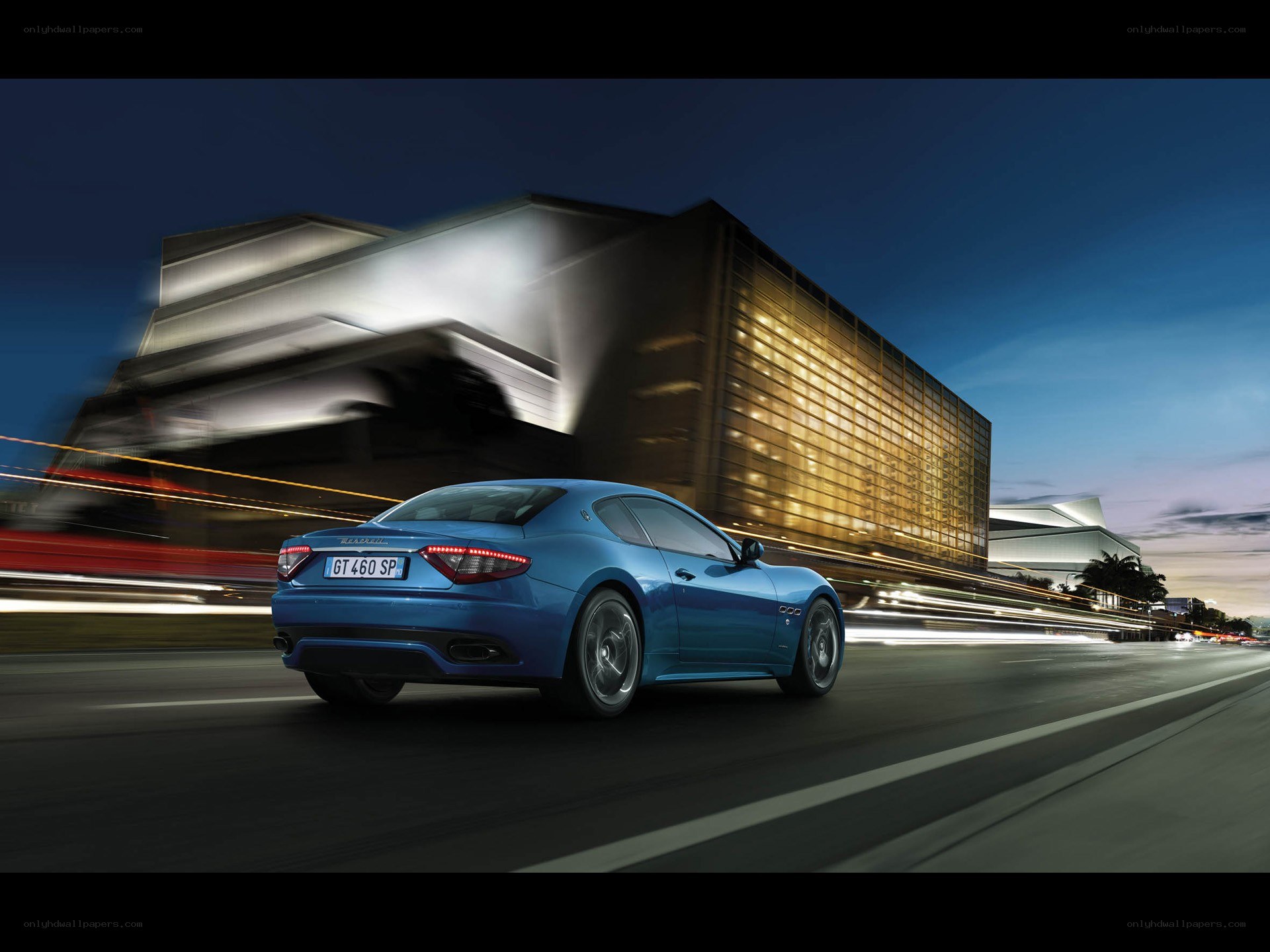 Blue Maserati driving at night