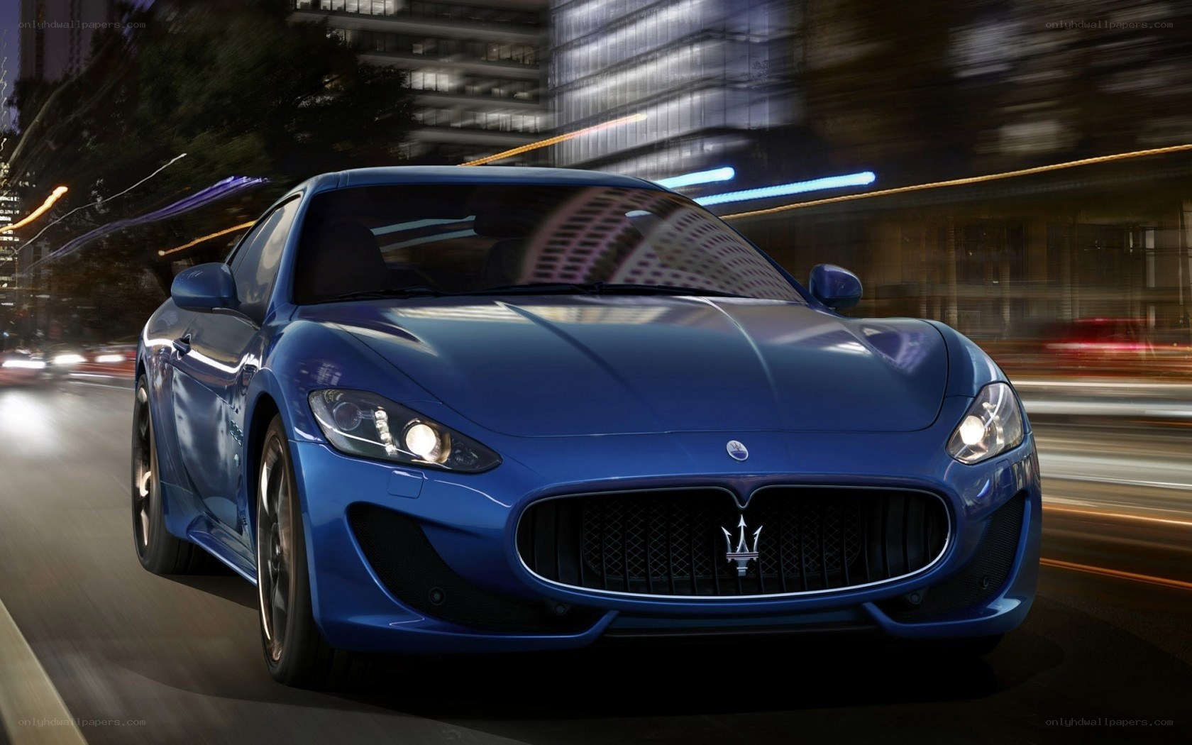 Blue Maserati driving at night