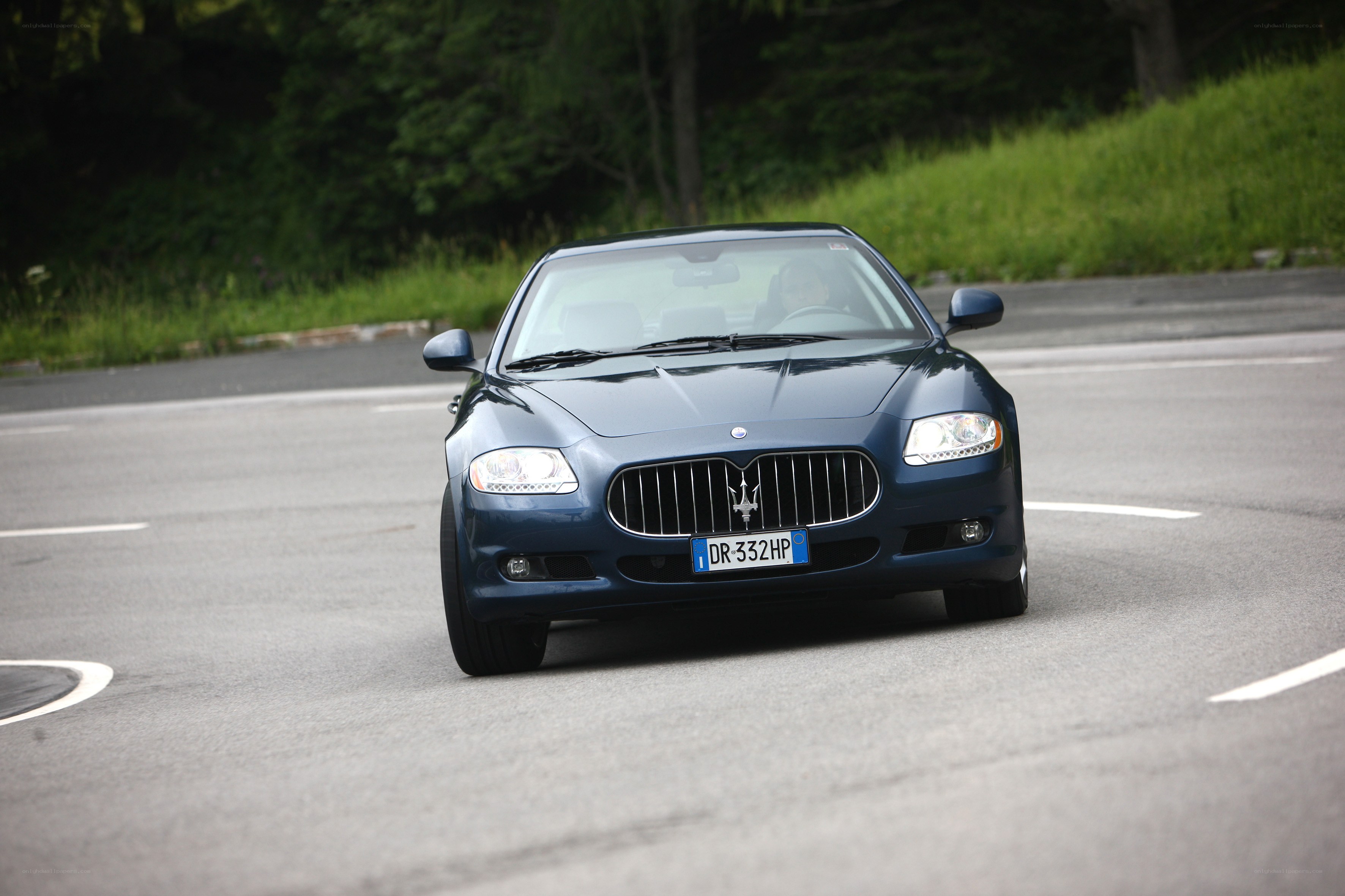 blue maserati driving on road