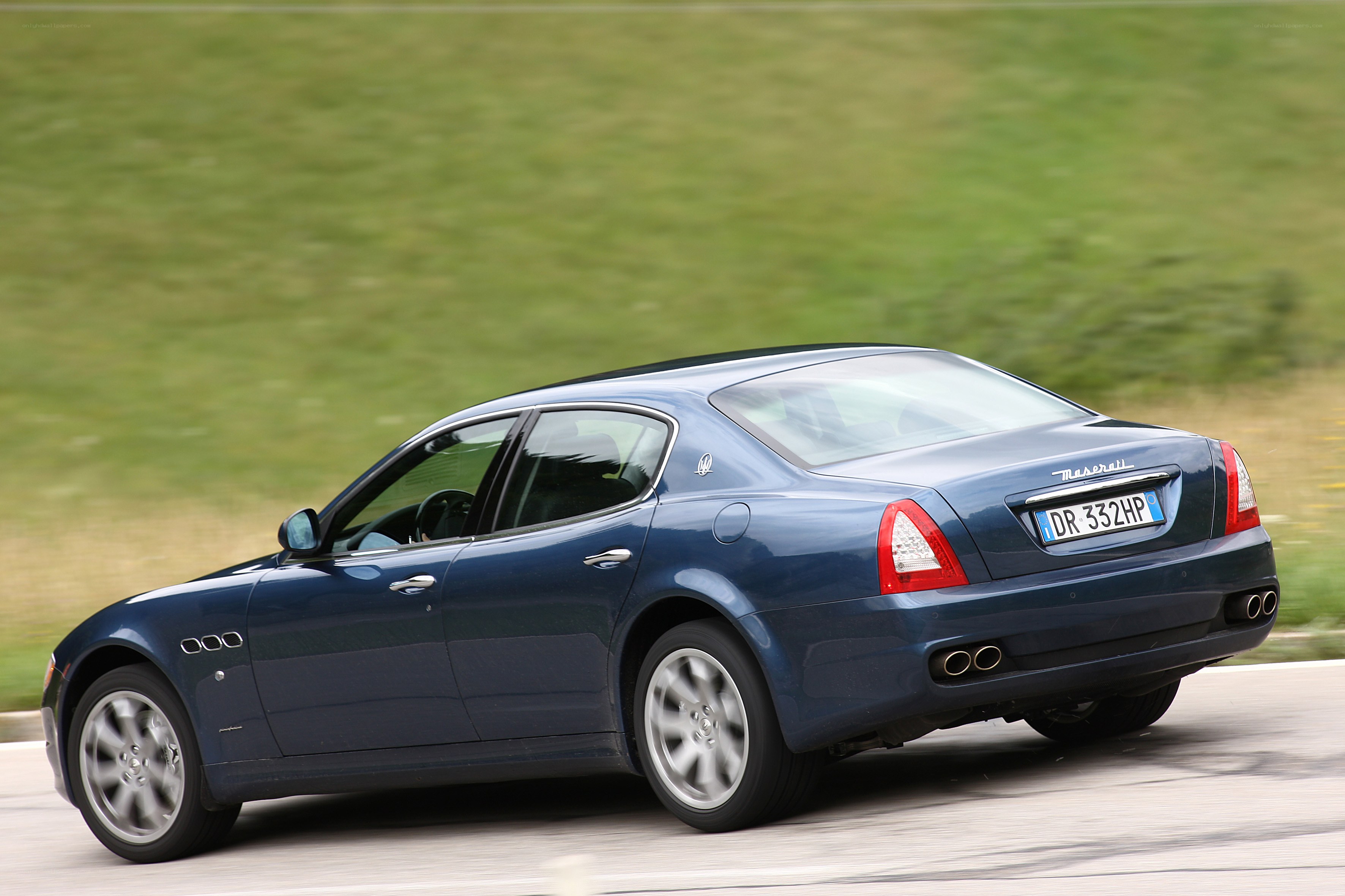 blue maserati driving on road