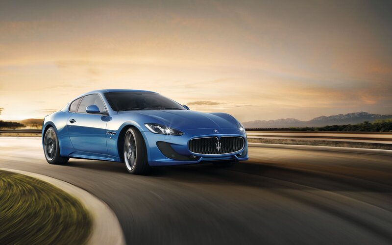 Blue Maserati on a winding road