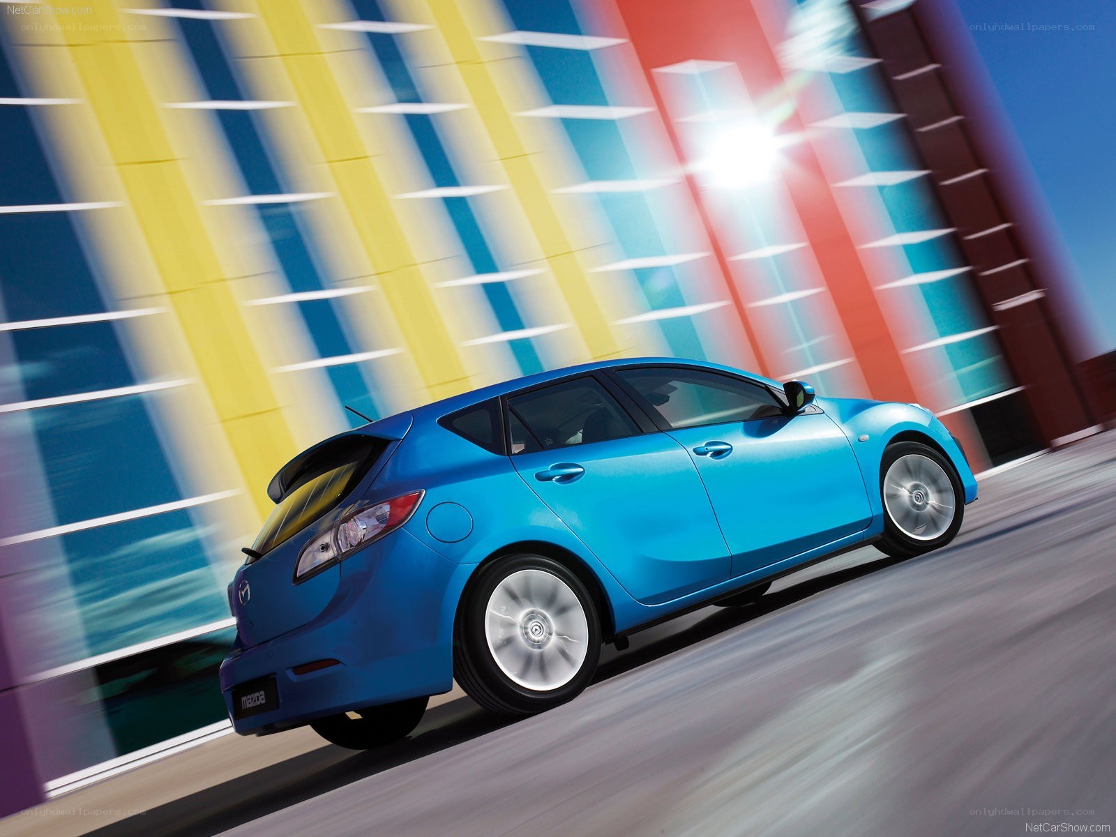 Blue Mazda 3 in motion