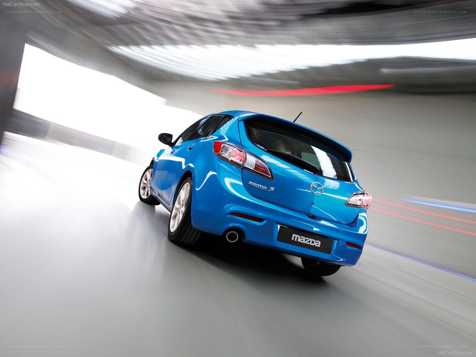 Blue Mazda 3 in motion