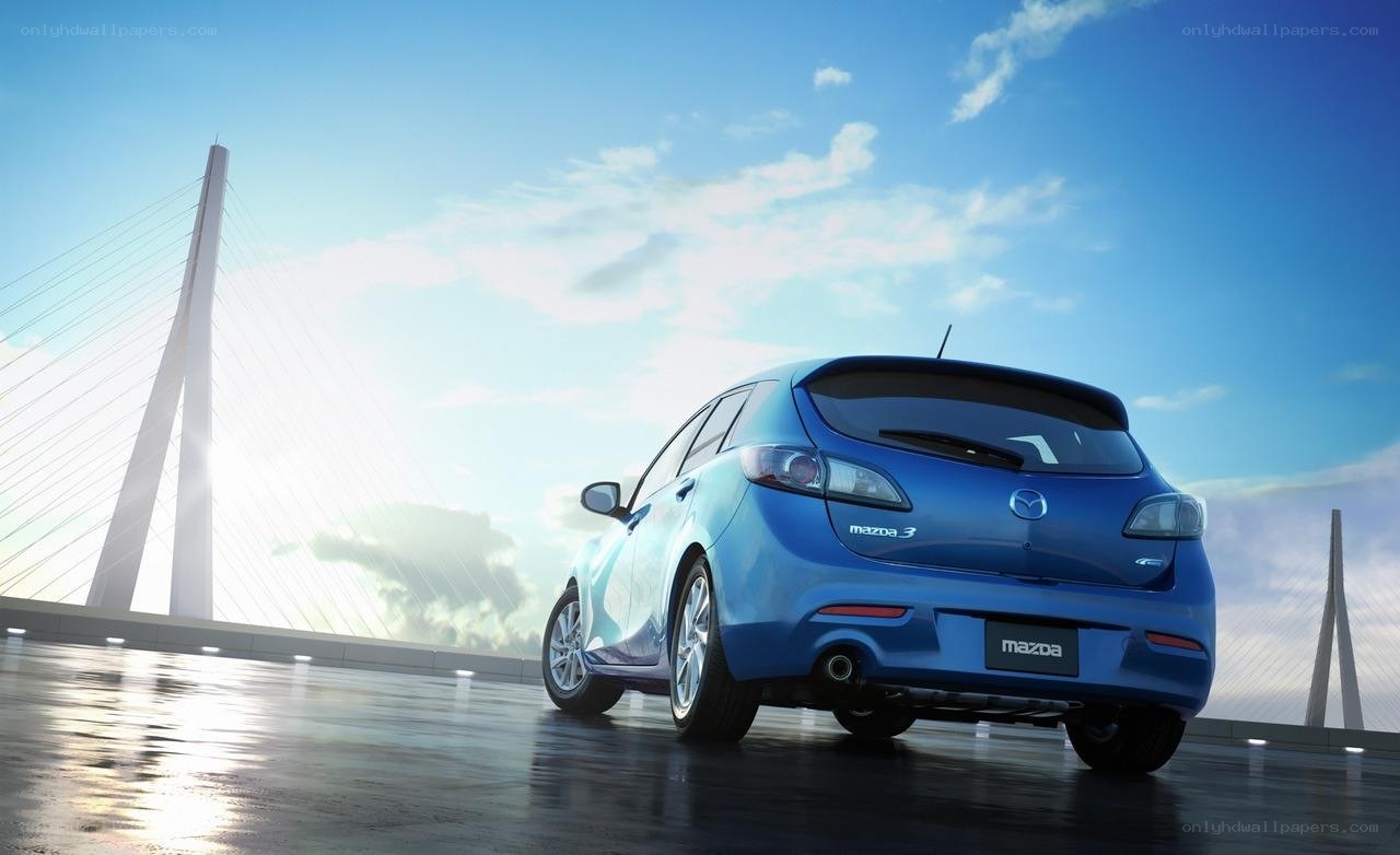 Blue Mazda 3 on a bridge