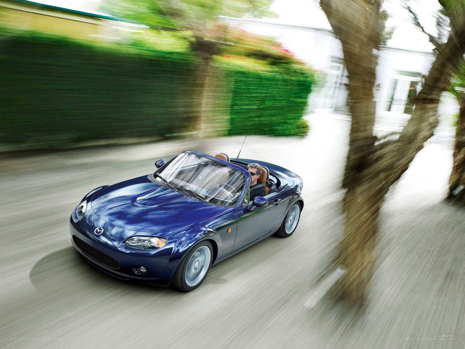 Blue Mazda Miata convertible in motion