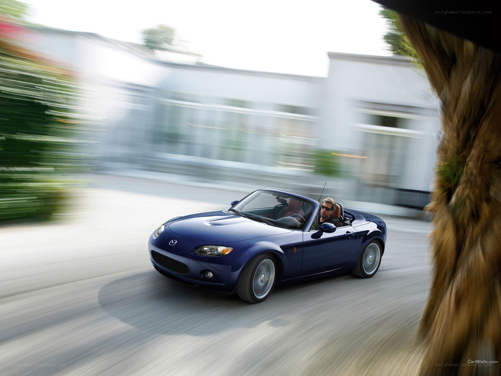 Blue Mazda Miata driving fast