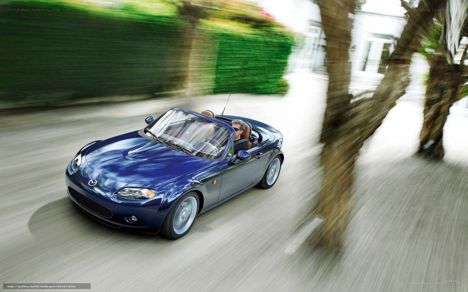 Blue Mazda Miata driving fast