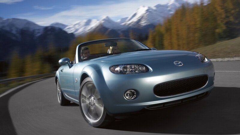 Blue Mazda Miata driving on mountain road