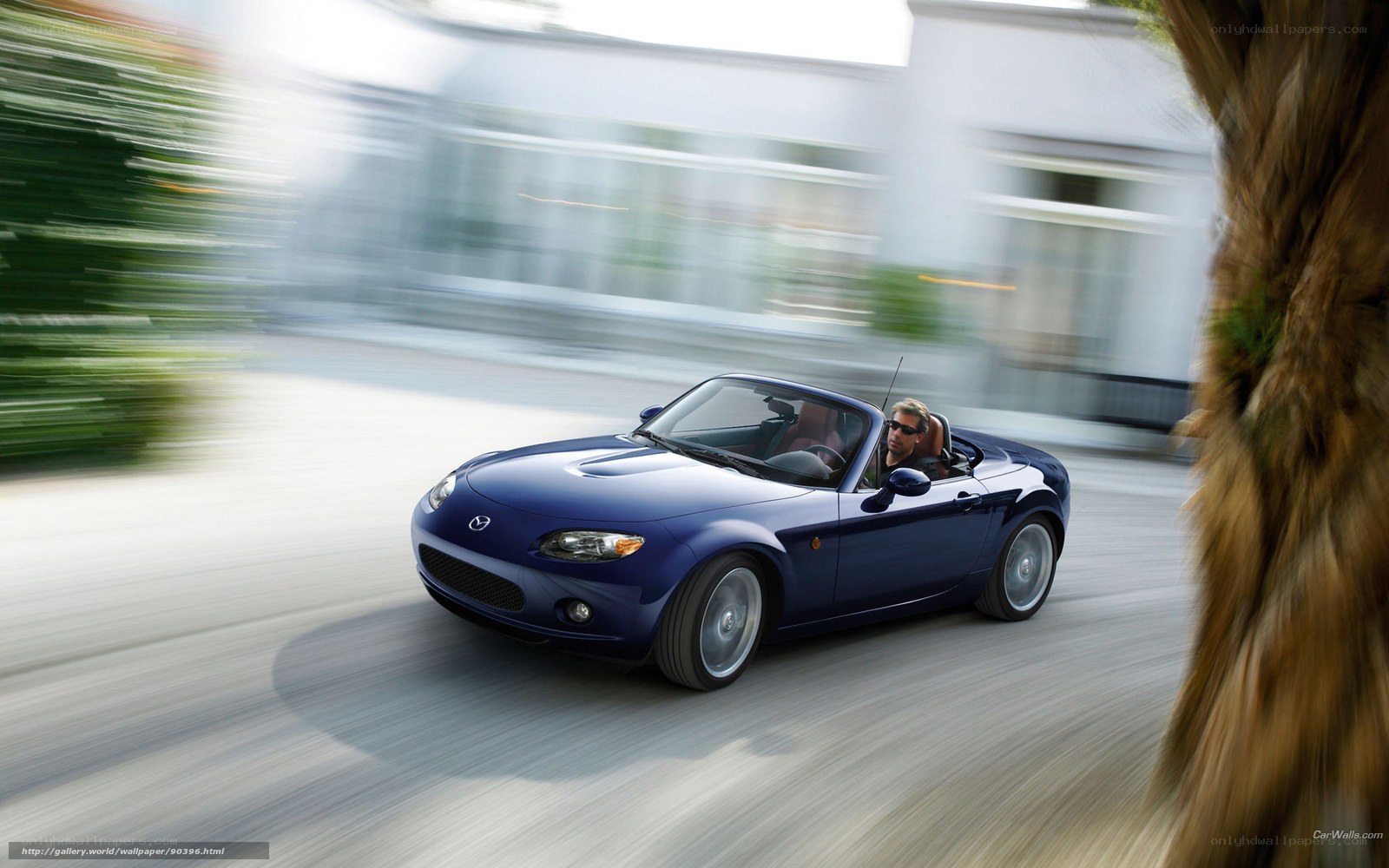 Blue Mazda Miata driving on road