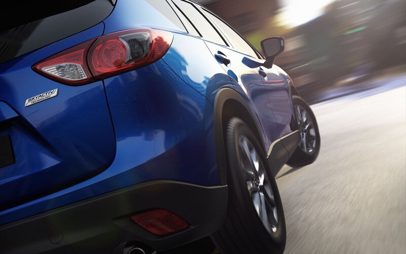 blue mazda suv in motion