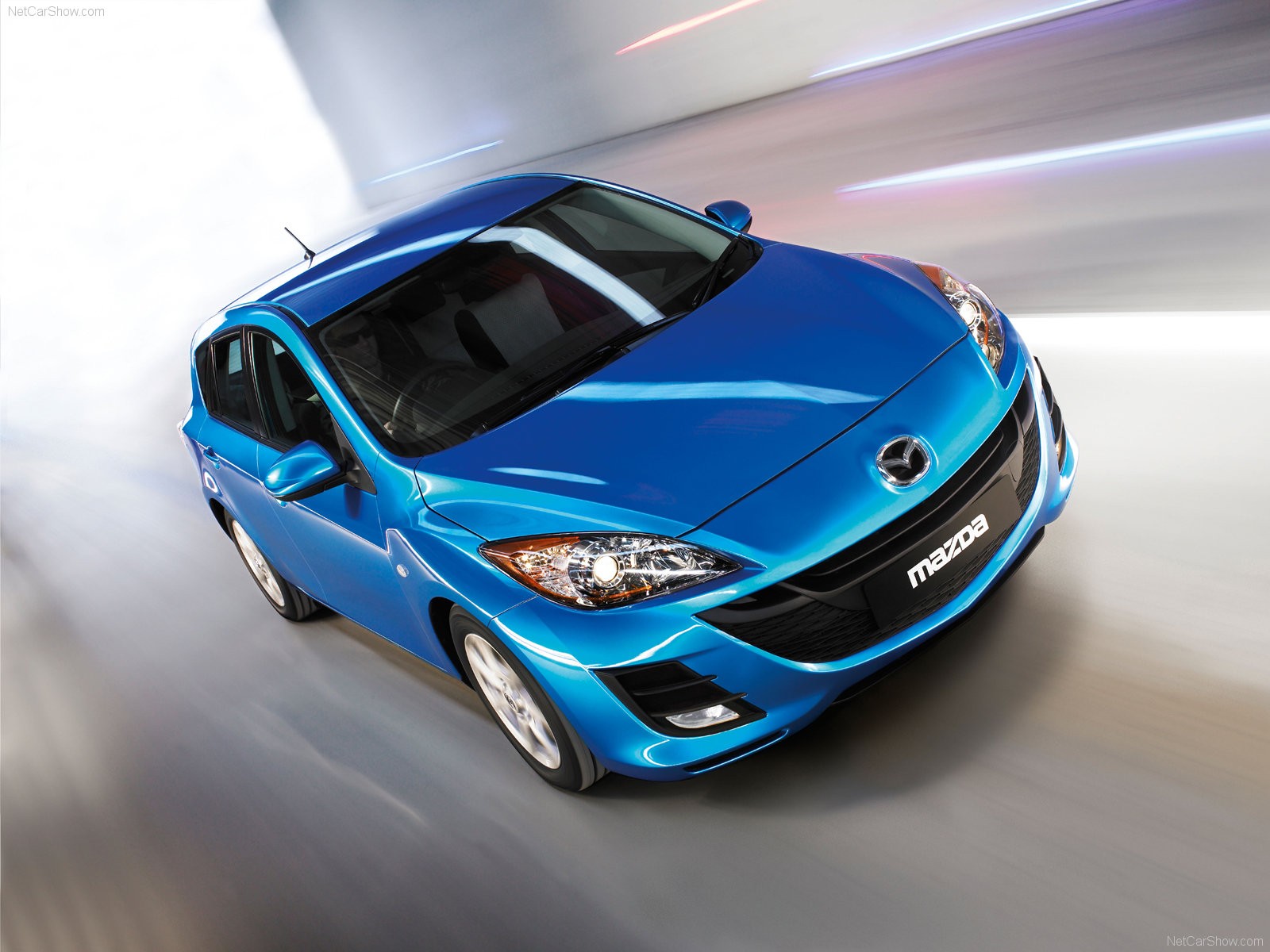 Blue Mazda3 in motion